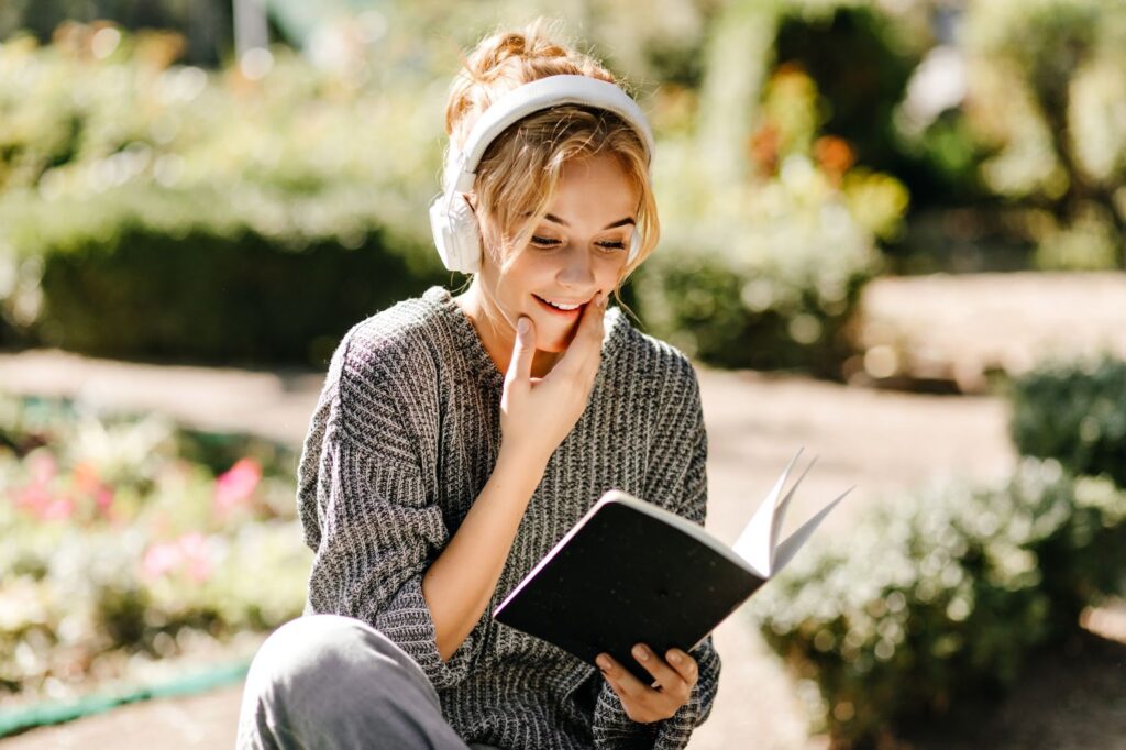 Woman listening to music and reading a book